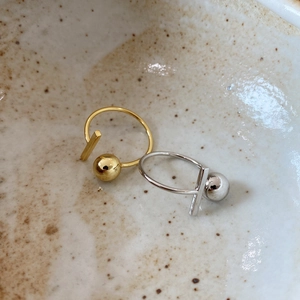 Detail of minimalist 925 silver rings with bead design on a ceramic plate