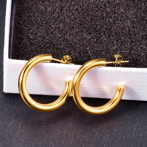 Modern gold-plated C-shaped hoop earrings with a polished mirror finish on a jewelry box
