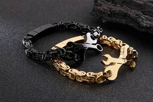 Détail du bracelet en forme de clé avec maillons en acier noir et or et tissage byzantin