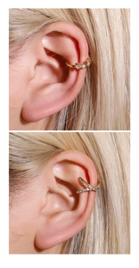 Detailed view of gold leaf star and cross ear cuffs with white rhinestones on ear