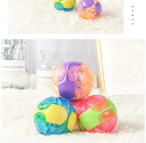 Close-up of textured colorful rubber dog balls with built-in bells on a soft rug