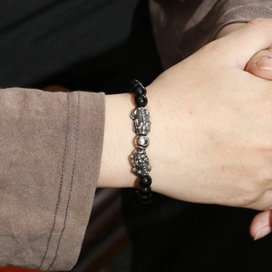 Men's street fashion beaded bracelet with silver Pi Xiu charms on a black obsidian band