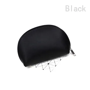 Close-up of semi-circular black faux leather clutch bag with silver metal zipper closure