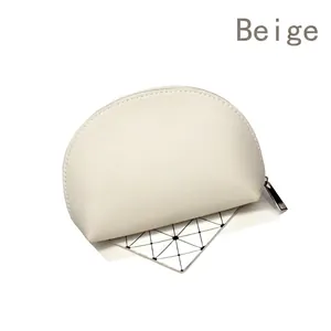 Close-up of a semi-circular beige PU leather makeup pouch with a silver metal zipper