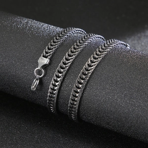Braided stainless steel men chain necklace with lobster clasp on a black display