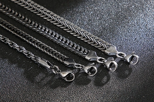 Detail of four different thickness stainless steel foxtail chains with lobster clasps