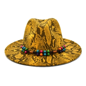 Detailed texture of bright yellow wool fedora featuring black snakeskin pattern and colorful beads