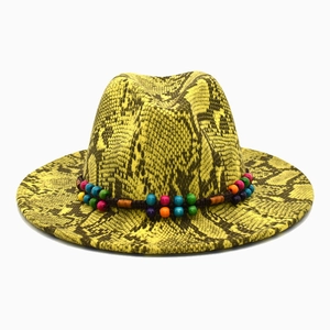 Detail of yellow snakeskin pattern fedora hat featuring a colorful bohemian beaded band