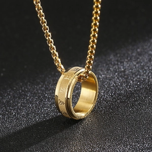 Rotating gold titanium steel ring necklace with engraved Sanskrit mantra on dark surface
