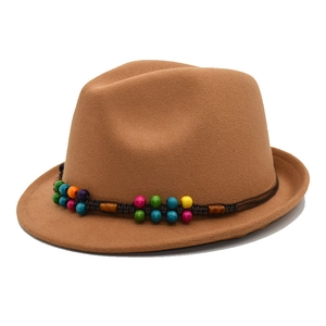Détail d'un chapeau en feutre avec ruban tressé et perles en bois multicolores