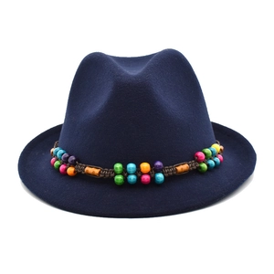 Détail du chapeau fedora bleu marine avec perles en bois colorées de style ethnique