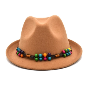Détail d'un chapeau en feutre kaki avec ruban ethnique orné de perles multicolores