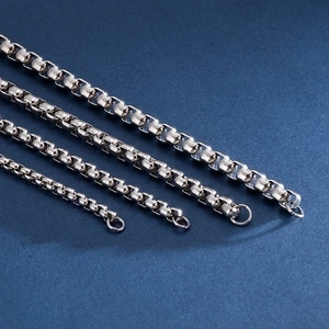Polished stainless steel box chain bracelets in four different widths on a blue background