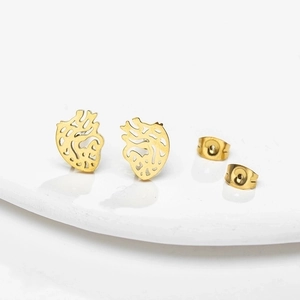 Minimalist hollow anatomical heart earrings in gold stainless steel on white ceramic plate