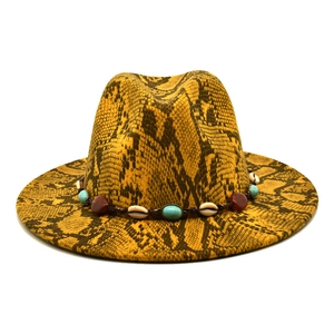 Detail of yellow snake pattern fedora hat featuring woven band and natural seashell accents