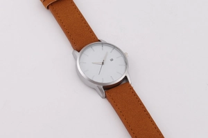 Vue détaillée d'une montre à quartz avec boîtier argenté, cadran blanc et cuir marron