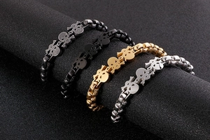 Detail of gothic skull steel bracelets in silver, gold, and black metallic finishes