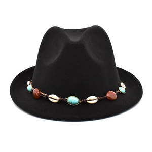 Détail d'un chapeau fedora noir en laine avec bandeau bohème en turquoise et coquillages