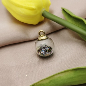 Macro view of a round glass pendant with colorful beads and crystal filling