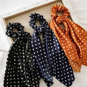 Polka dot hair scrunchies with long ribbons in black, navy, and orange textile fabric
