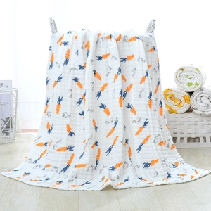 Close-up of 6-layer cotton gauze baby blanket with carrot and bunny prints in a basket