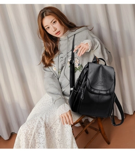 Detail of black PU leather backpack showing embossed kangaroo logo and smooth zipper