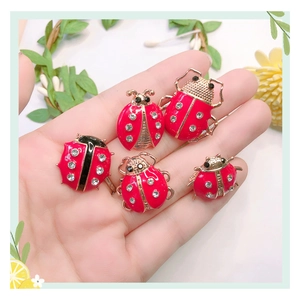 Detail of five creative ladybug brooches with red enamel and sparkling crystals