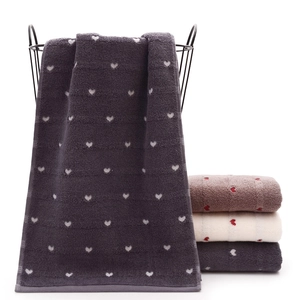 Macro detail of soft cotton towels with heart jacquard pattern in elegant neutral colors