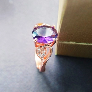 Detailed macro view of an oval purple amethyst ring in rose gold with heart-shaped cutouts