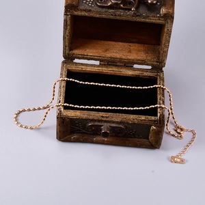 Close-up of 18K gold beaded chain necklace with K18 engraved tag and spring clasp