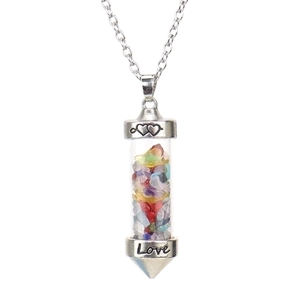 Detail of love engraved base on cylinder glass pendant filled with colorful crushed stones