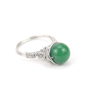 Detail of silver wire-wrapped ring featuring a green natural crystal bead