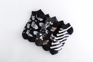 Detail of five pairs cotton crew socks with geometric, camo and cartoon patterns