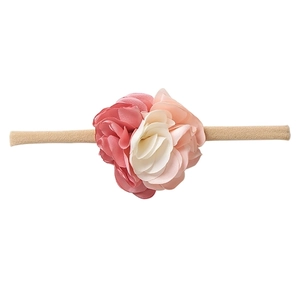 Close-up of pink and beige nylon floral headbands with soft elastic texture for infants