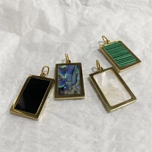 Detail of four rectangular pendants in gold-plated steel with shell and stone inlays
