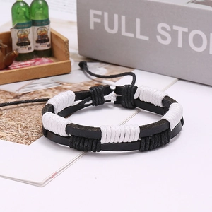 Detail of retro braided leather bracelet featuring black and white woven cords and slider