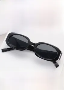 Close-up of retro black oval sunglasses on a minimalist white geometric display stand