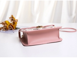 Detail view of pink daisy jelly crossbody bag with gold metal lock and side texture