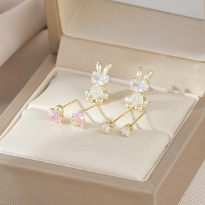 Macro detail of golden bunny earrings set with pink hearts and sparkling cubic zirconia
