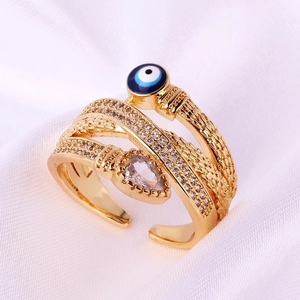 Macro shot of gold snake ring with evil eye detail and pear-shaped zircon stones
