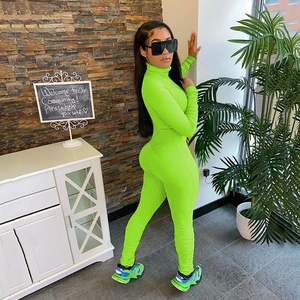 Side view of a vibrant neon green ribbed bodysuit featuring a high neck and long sleeves