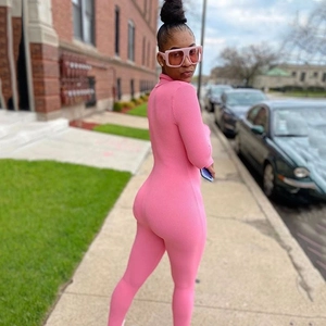 Pink long sleeve ribbed knit jumpsuit for women shown in a stylish outdoor street setting