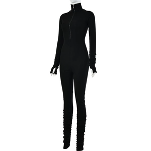 Detail of black long sleeve jumpsuit featuring a high neck zipper and ruched texture cuffs