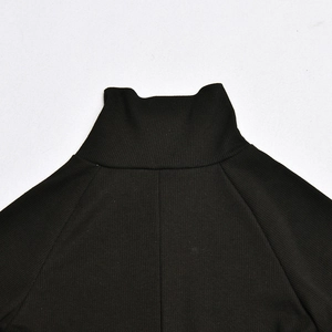 Detail shot of black ribbed knit bodysuit showing high neck and shoulder fabric texture