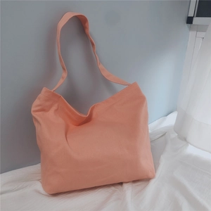 Detail view of the apricot orange canvas tote bag with its durable shoulder strap
