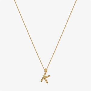 Detail of gold S925 silver letter K pendant with irregular texture and small crystals