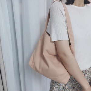 Close-up of minimalist light pink canvas tote bag showing texture and wide strap