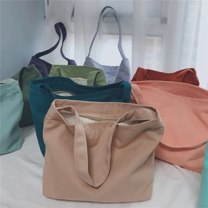 Detailed view of various colorful canvas tote bags with zipper closures and handles