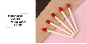Close-up of creative matchstick-shaped ballpoint pens in a fan arrangement on a notebook