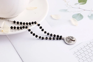Detail of life tree silver pendant necklace with faceted black glass beads